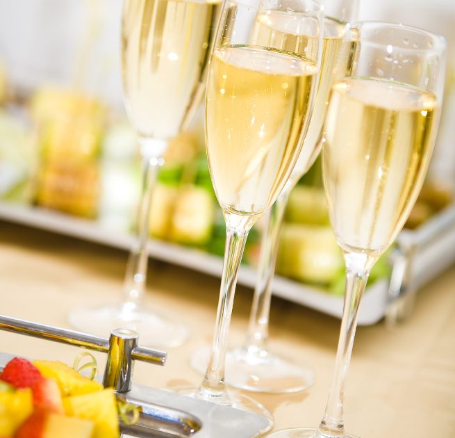 four champagne glasses on serve table